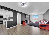 Spacious living room featuring a modern black and red sectional sofa, city views, and sleek wall accents at 3930 University Center Dr # 909, Las Vegas, NV 89119