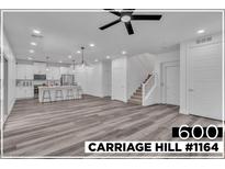 Bright, open-concept living space featuring a modern kitchen with stainless steel appliances and a stylish staircase at 600 N Carriage Hill Dr # 1164, Las Vegas, NV 89138
