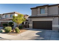 Inviting home exterior featuring a two-car garage, desert landscaping, and a well-maintained lawn at 717 W Colton Ave, North Las Vegas, NV 89032