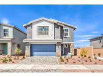 Charming two-story home featuring a stone-accented facade, paver driveway, and well-maintained landscaping at 1027 Gentle Swan St # 689, Henderson, NV 89011