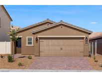 Charming single-story home showcasing a two-car garage and well-maintained landscaping under a clear blue sky at 1713 Desert Path Ave, North Las Vegas, NV 89032