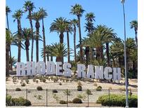 Picturesque view of the 'Rhodes Ranch' sign surrounded by tall palm trees and desert landscaping at 172 Tall Ruff Dr, Las Vegas, NV 89148