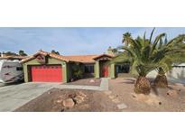 Charming single-story home with a red garage door, red front door, desert landscaping, and mature palm trees at 2540 Hummingbird Hill Ave, Henderson, NV 89074