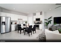Modern kitchen featuring stainless steel appliances, white cabinets, and an adjacent dining area at 474 Ylang Pl # Lot 7, Henderson, NV 89015