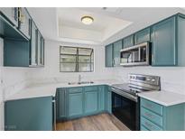 Updated kitchen features attractive blue cabinets, stainless appliances and stunning white counters at 7200 Pirates Cove Rd # 2089, Las Vegas, NV 89145
