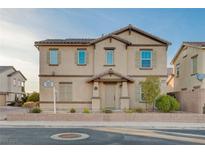 Charming two-story home with tan stucco, low-maintenance landscaping, and a cozy covered front porch at 1045 Spotted Saddle St, Henderson, NV 89015