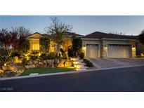 Inviting home exterior with manicured landscaping, rock features, and a paved driveway leading to a two-car garage at 10813 Oak Shadow Ave, Las Vegas, NV 89144