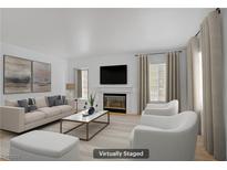 Bright living room with modern fireplace, neutral tones, and large windows at 202 Bastrop St, Henderson, NV 89074