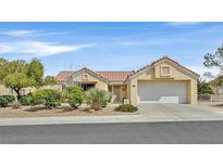 Single-story home featuring a two-car garage, desert landscaping, and a tile roof at 2608 Saltbush Dr, Las Vegas, NV 89134