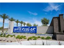 Watercolor planned community entrance sign with palm trees under a sunny blue sky at 2765 Frosted Teal Ave, North Las Vegas, NV 89086