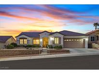 Charming single-story home with a well-manicured front yard and a two-car garage under a lovely sunset at 3042 Lake Barkley Rd, Henderson, NV 89052
