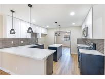Modern kitchen features white cabinets, a center island and stainless steel appliances at 3119 Desmond Ave, Las Vegas, NV 89121