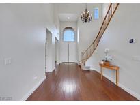 Bright foyer features wood floors, high ceilings, staircase, chandelier, and arched window above the double front doors at 3728 White Lion Ln, North Las Vegas, NV 89084