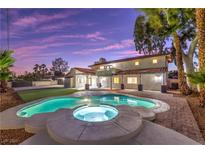 A backyard pool and spa are surrounded by a large grassy area and palm trees at 5750 Edna Ave, Las Vegas, NV 89146