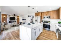 Open-concept living space with a modern kitchen, fireplace, and comfortable seating area at 7832 Desert Candle Way, Las Vegas, NV 89128