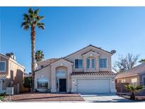 Charming two-story home with a well-manicured lawn and a beautiful palm tree in the front yard at 9139 Scallop Reef Ave, Las Vegas, NV 89147