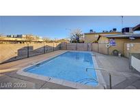Community pool with a metal fence and clean blue water on a sunny day at 3821 1/2 Daisy St # 25, Las Vegas, NV 89119