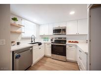 Bright kitchen featuring stainless steel appliances, white cabinets, and light wood floors at 3823 S Maryland Pkwy # L6, Las Vegas, NV 89119