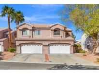 Charming townhome with tile roof, dual garage doors, and desert landscaping under a sunny, blue sky at 5382 Runningbrook Rd, Las Vegas, NV 89120