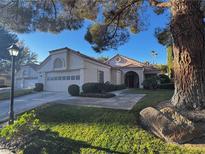 Inviting single-story home featuring a tile roof, well-kept lawn, and charming curb appeal at 7732 Tinted Mesa Ct, Las Vegas, NV 89149