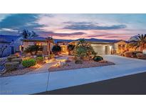 Stunning single-story home featuring beautiful desert landscaping with walkway and well-lit exterior at dusk at 2167 Fairweather St, Henderson, NV 89052