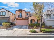 Two-story home with a pink garage door, archway and a small balcony on a sunny day at 2851 Glistening Grove Ave, Henderson, NV 89052