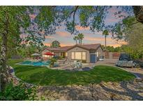 Spacious backyard featuring a pool, lush lawn, and mature landscaping, perfect for outdoor entertaining at 337 Glenridding St, Las Vegas, NV 89183