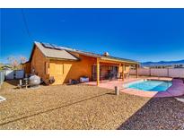 Charming backyard featuring a refreshing pool, covered patio, and low-maintenance desert landscaping at 3424 Mount Charleston Dr, Pahrump, NV 89048