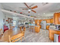 Open kitchen featuring wood cabinets, stainless steel appliances, an island and an adjacent dining area at 3424 Mount Charleston Dr, Pahrump, NV 89048