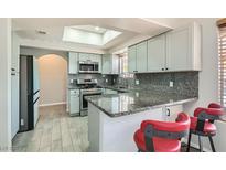 Charming kitchen features gray cabinets, granite counters, and a skylight for natural light at 508 Indian Princess Dr # 104, Las Vegas, NV 89145