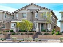 Charming townhome featuring a landscaped front yard and welcoming entrance with a lovely green door at 712 N Water St, Henderson, NV 89015