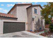 Tan two-story home with a two car garage, red tile roof, and minimal landscaping at 7940 Violet Dawn St, Las Vegas, NV 89149
