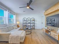 Bright living room features a plush sofa, sleek ceiling fan, and modern shelving for stylish storage at 10768 Ditchburn Ct, Las Vegas, NV 89166