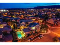 Dusk aerial view shows a vibrant neighborhood with a private pool in the backyard and mountain views at 2098 Valley Sand St, Las Vegas, NV 89135