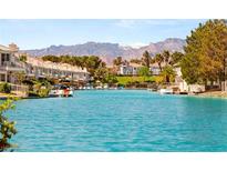 Scenic waterfront community with a turquoise waterway, mountain views and boats docked outside residences at 3173 Lido Isle Ct, Las Vegas, NV 89117