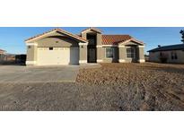 Charming single-story home with a two-car garage, a front yard with xeriscaping, and a red tile roof at 3326 Mount Charleston Dr, Pahrump, NV 89048