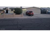 Charming home with manicured front yard, desert landscaping, and a red vehicle parked in the driveway at 4363 Del Santos Dr, Las Vegas, NV 89121