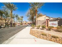 View of Altair Pointe community entrance with desert landscaping and palm trees on a sunny day at 4423 Creekside Cavern Ave, North Las Vegas, NV 89084
