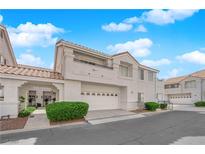Inviting townhome featuring a two-car garage and covered walkway leading to the entrance at 5201 S Torrey Pines Dr # 1223, Las Vegas, NV 89118