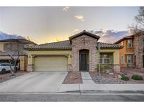 Inviting single-story home boasts a stone facade, tile roof, and attached two-car garage at 6077 Honeysuckle Ridge St, Las Vegas, NV 89148