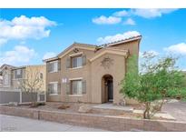 Charming two-story home with tan stucco, low brick wall and an arched entry at 963 Sable Chase Pl, Henderson, NV 89011