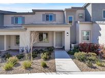 Inviting townhouse with neutral stucco, gray trim, well-maintained landscaping, and a welcoming front entryway at 10774 Clarence Ct, Las Vegas, NV 89166