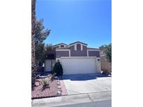 Two-story home with a two car garage and landscaped front yard under a clear blue sky at 1655 Morse Arberry Ave, Las Vegas, NV 89106