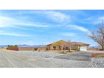 Spacious desert home featuring rock landscaping, ample parking, and mountain views at 1830 E Fuchsia St, Pahrump, NV 89048