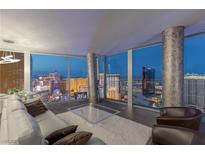 Modern living room with floor-to-ceiling windows offering spectacular city views and comfortable leather furniture at 3722 Las Vegas Blvd # 2904, Las Vegas, NV 89158