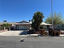 Single-story home featuring a wide driveway and mature palm tree, offering a charming curb appeal at 516 Donner St, Las Vegas, NV 89107