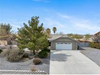Charming single-story home featuring desert landscaping, a two-car garage, and a welcoming exterior at 6860 Stubblefield Dr, Pahrump, NV 89061