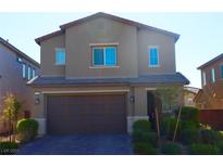 Two-story home boasts a well-manicured front yard, dark brown trim, and a large two car garage at 7022 Judith River St, North Las Vegas, NV 89084