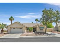 Charming one-story home with a two-car garage, low maintenance desert landscaping, and palm trees at 880 Autumn Canyon Way, Henderson, NV 89002