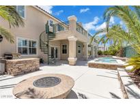 Outdoor patio features a fire pit, outdoor kitchen, and a second-story balcony with spiral staircase at 3088 Via Flaminia Ct, Henderson, NV 89052